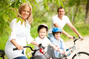 healthy woman and family on bikes with smile